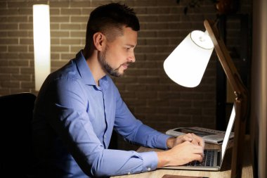 Gece geç saatlerde ofiste çalışan bir adam.