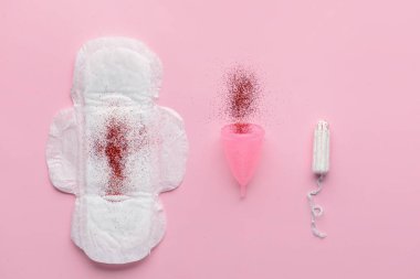 Menstrual pad, cup and tampon with red glitter on color background. Menstruation concept clipart
