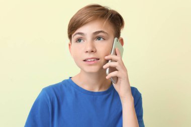 Renkli arka planda cep telefonuyla konuşan çocuk