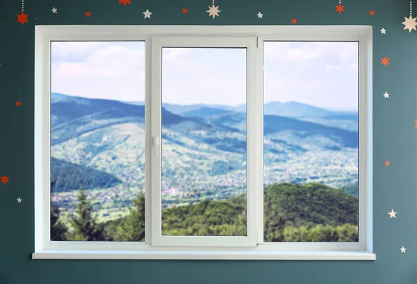 Vista em belas montanhas através de grande janela de metal-plástico — Fotografia de Stock