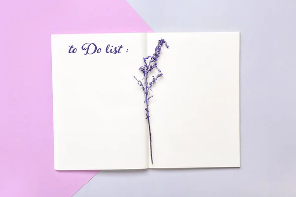 Notebook with blank to-do list and lavender flowers on color background — Stock Photo, Image