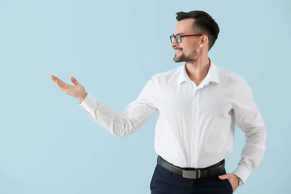 Retrato de un joven empresario mostrando algo sobre el fondo de color —  Fotos de Stock