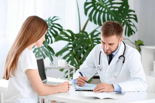 Male doctor working with female patient in clinic — Stock Photo, Image