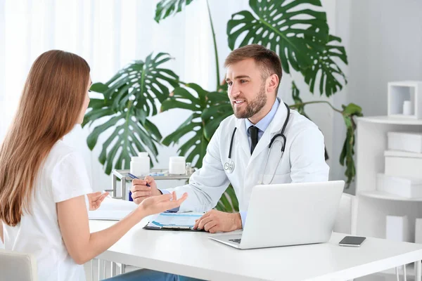 Male doctor working with female patient in clinic — Stock Photo, Image