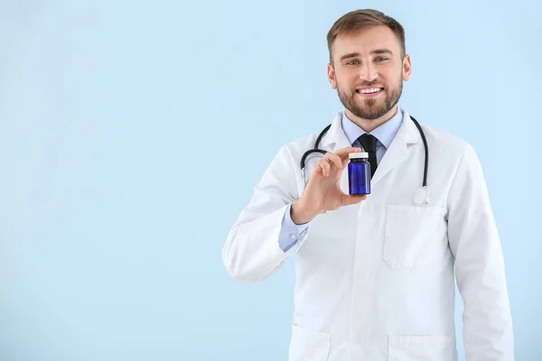 Retrato de médico masculino com pílulas em fundo claro — Fotografia de Stock