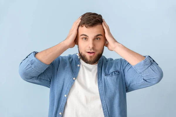 Surprised young man on color background — Stock Photo, Image