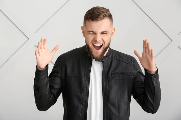 Screaming young man on grey background — Stock Photo, Image