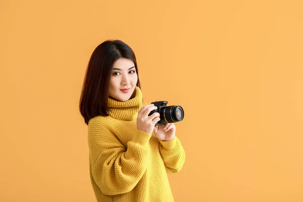 Mooie Aziatische fotograaf op kleur achtergrond — Stockfoto