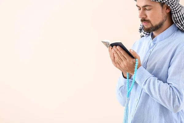 Hombre musulmán con Corán y cuentas sobre fondo claro — Foto de Stock