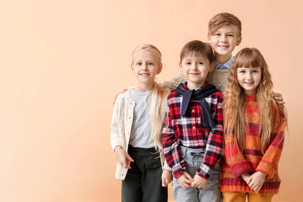 Aranyos kis gyerekek ősszel ruhák közelében színes fal — Stock Fotó