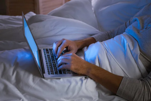 Man with laptop in bed at night — Stock Photo, Image