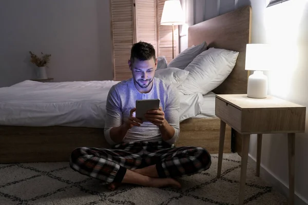 Uomo con tablet PC in camera da letto di notte — Foto Stock