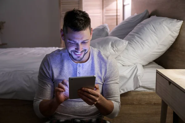 Uomo con tablet PC in camera da letto di notte — Foto Stock
