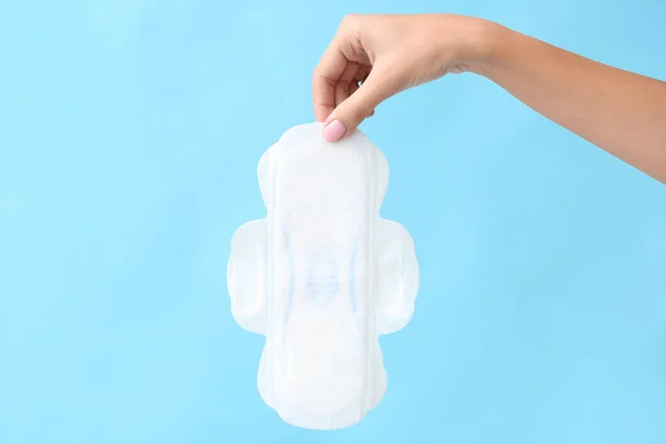 Női kéz menstruációs pad színes háttér — Stock Fotó