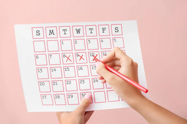 Woman with menstrual calendar on color background — Stock Photo, Image