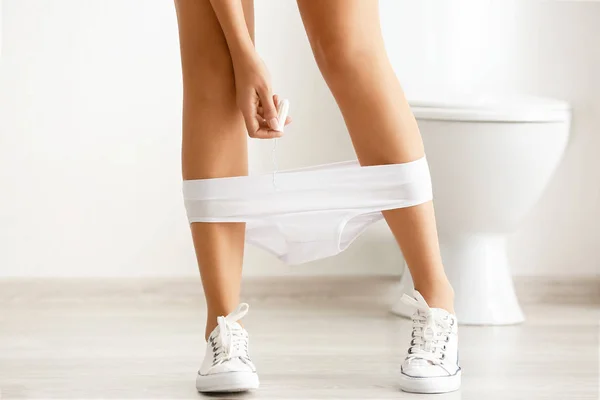 Vrouw met uitgegleden slipje en tampon in toilet — Stockfoto