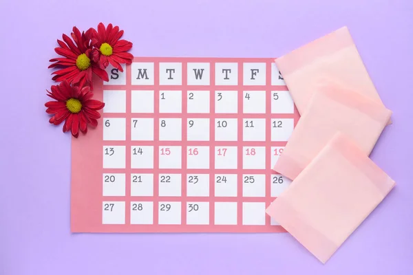 Menstrual calendar with pads on color background — Stock Photo, Image