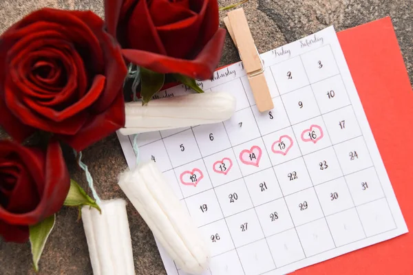 Calendário menstrual com tampões e flores em fundo cinza — Fotografia de Stock