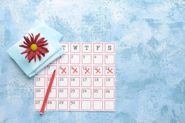 Calendário menstrual com almofadas em fundo de cor — Fotografia de Stock