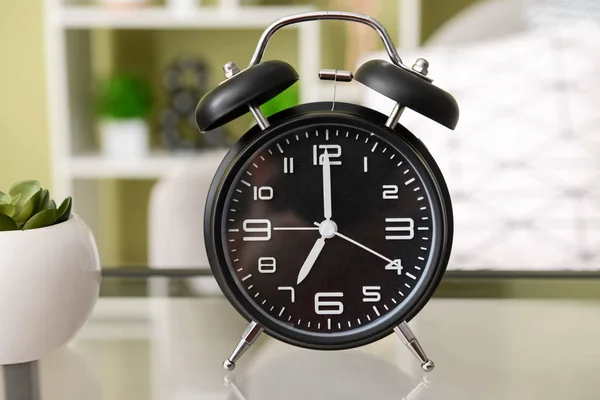 Relógio despertador na mesa no quarto — Fotografia de Stock
