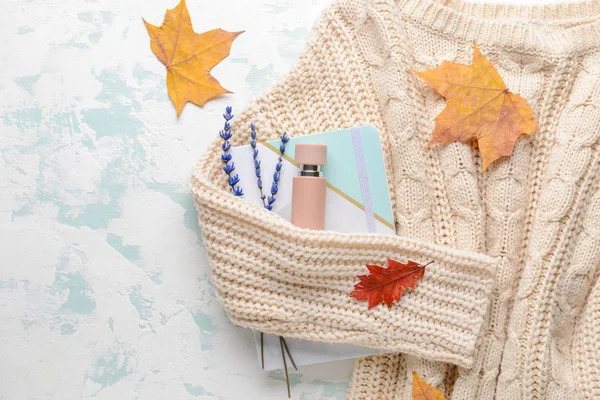 Composição de outono com garrafa de perfume e suéter sobre fundo branco — Fotografia de Stock