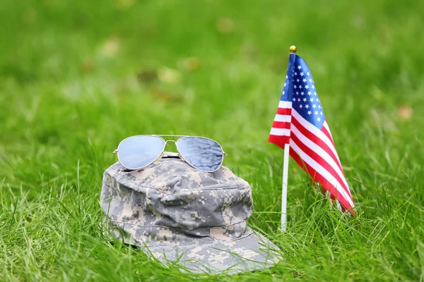 Vojenský klobouk, sluneční brýle a americká vlajka venku. Slavnost Memorial Day — Stock fotografie