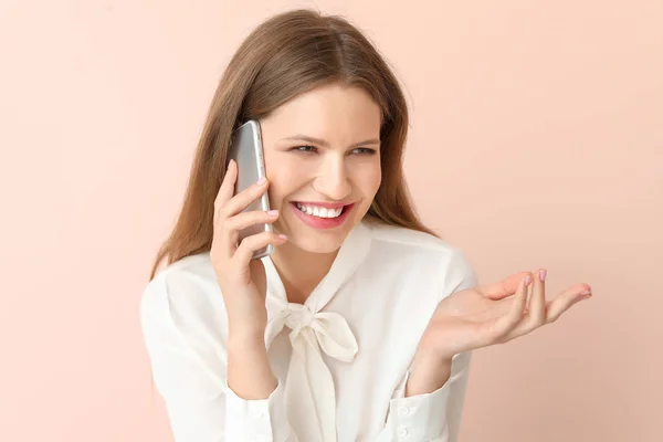 Happy businesswoman talking by mobile phone on color background — Stock Photo, Image