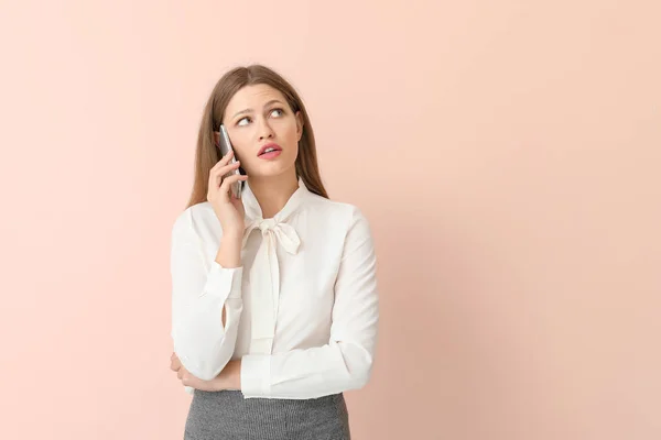 Junge Geschäftsfrau telefoniert auf farbigem Hintergrund — Stockfoto