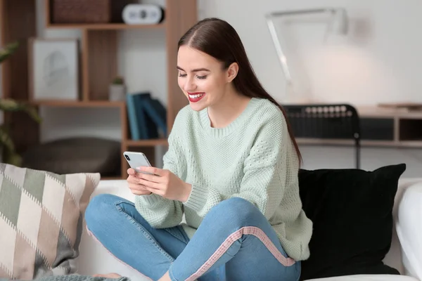 Mulher bonita com telefone celular em casa — Fotografia de Stock