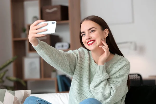 Beautiful young woman taking selfie at home — Stock Photo, Image