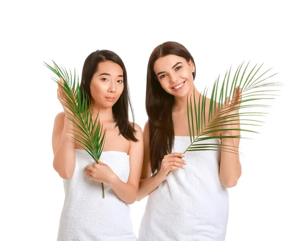 Gyönyörű fiatal nők egészséges bőr és trópusi levelek fehér alapon — Stock Fotó