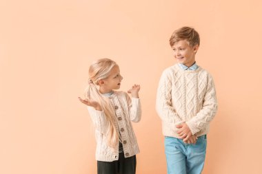 Sonbahar kıyafetleri içinde, renkli arka planda şirin çocuklar.