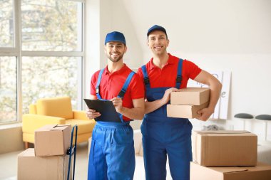 Odasında bir sürü kutu taşıyan teslimatçılar.