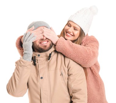 Mutlu kadın beyaz arka planda erkek arkadaşının gözlerini kapatıyor.