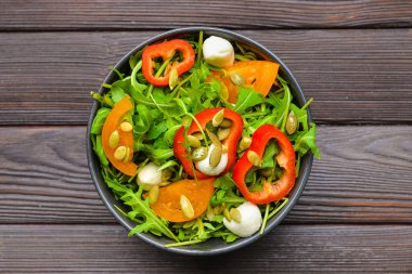 Ahşap arka planda lezzetli salata ile Tabak