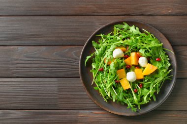 Ahşap arka planda lezzetli salata ile Tabak