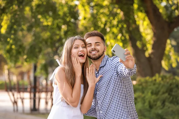 Happy engaged couple taking selfie outdoors — 스톡 사진