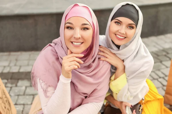 Schöne muslimische Frauen mit Einkaufstüten im Freien — Stockfoto