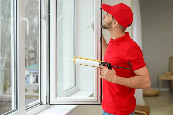 Jovem trabalhador instalando janela em plano — Fotografia de Stock