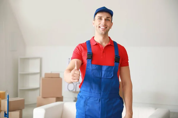 Loader showing thumb-up in flat on moving day — 스톡 사진