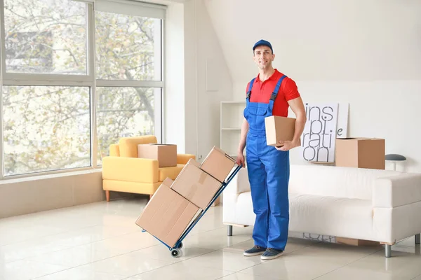 Delivery man with boxes in room