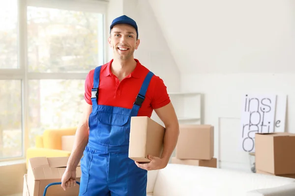 Delivery man with boxes in room