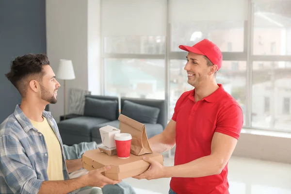Man receiving order from courier of food delivery company — 스톡 사진