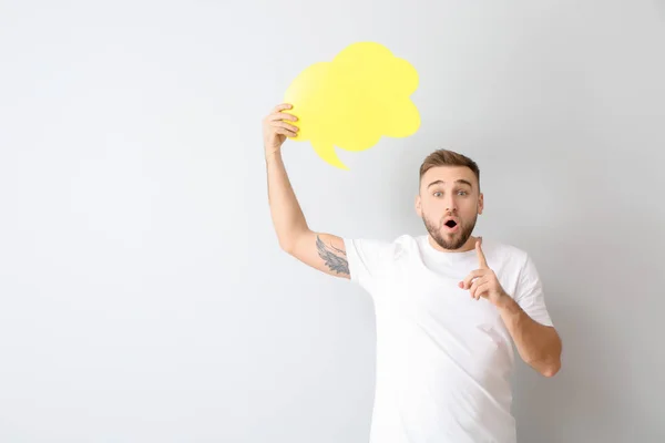 Joven sorprendido con burbuja de habla en blanco sobre fondo claro — Foto de Stock