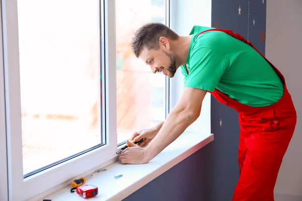 Mężczyzna pracownik montaż okno w mieszkanie — Zdjęcie stockowe