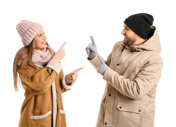 Portrait of happy couple in winter clothes showing something on white background — Stock Photo, Image