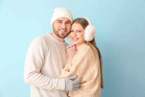 Portrait of happy couple in winter clothes on color background — Stock Photo, Image