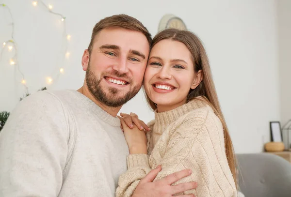 Feliz joven pareja descansando en casa en Nochebuena —  Fotos de Stock