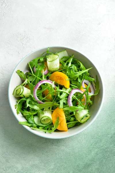 Tigela com salada saborosa no fundo claro — Fotografia de Stock