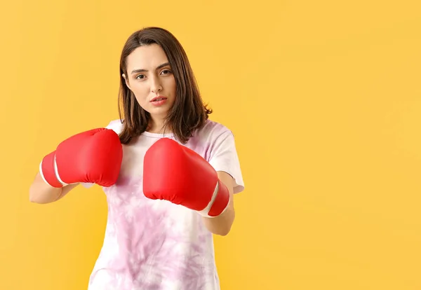 Жінка в боксерських рукавичках на кольоровому фоні. Концепція фемінізму — стокове фото